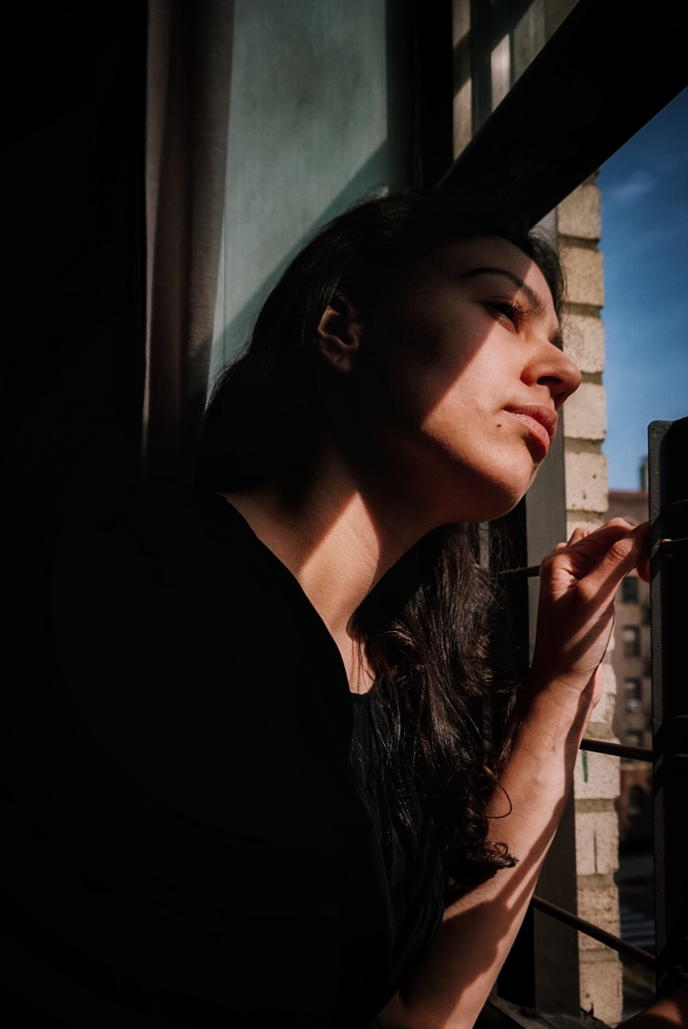 nyc girl looking out from window during covid19